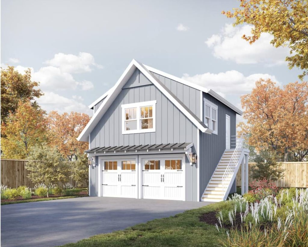 view of property exterior featuring a standing seam roof, stairway, fence, concrete driveway, and an attached garage
