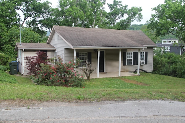 view of front of home featuring a shingled roof and a front yard