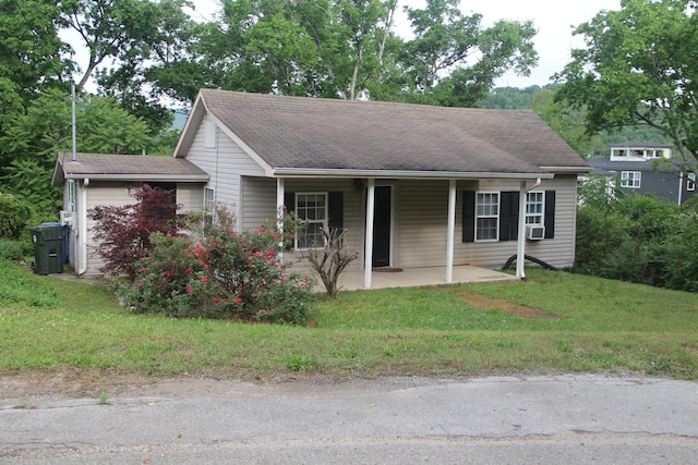 view of front facade featuring roof with shingles and a front yard