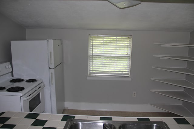 kitchen with tile counters, white electric range oven, and baseboards