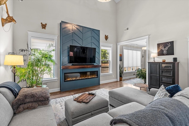 1383 Carrington Way, Chattanooga, TN 37405 - living room with wood finished floors, visible vents, baseboards, a towering ceiling, and a glass covered fireplace