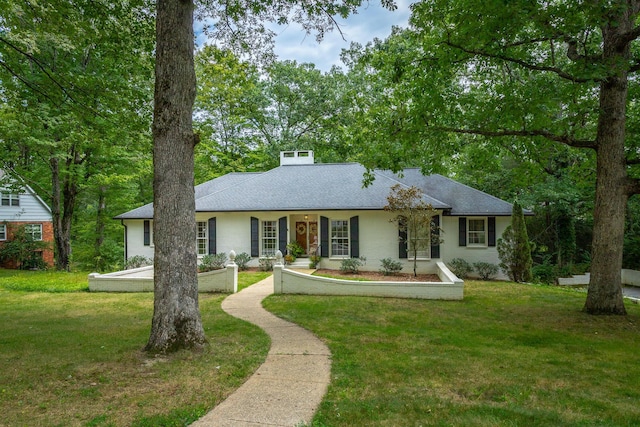 ranch-style house featuring a front lawn and roof with shingles