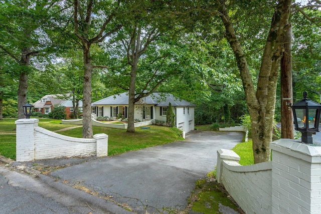 view of front of house featuring a front lawn, driveway, and an attached garage