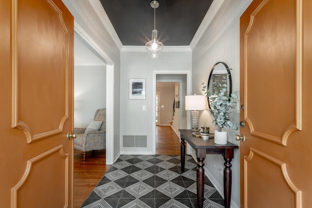 foyer entrance featuring ornamental molding, baseboards, dark wood-style floors, and visible vents