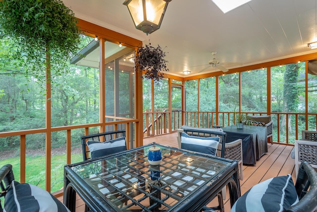 sunroom with outdoor dining area and ceiling fan