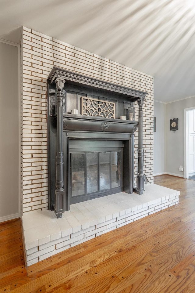 details featuring a fireplace, baseboards, and wood finished floors