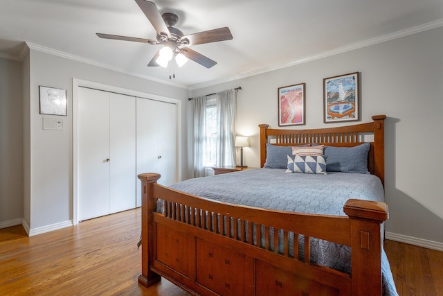 bedroom featuring baseboards, ornamental molding, a closet, and light wood-type flooring