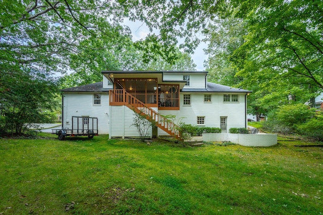 back of property featuring a yard, a sunroom, and stairs
