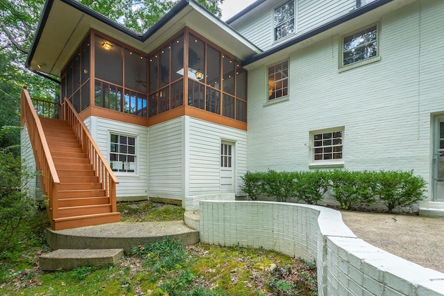 back of house with stairway and a sunroom