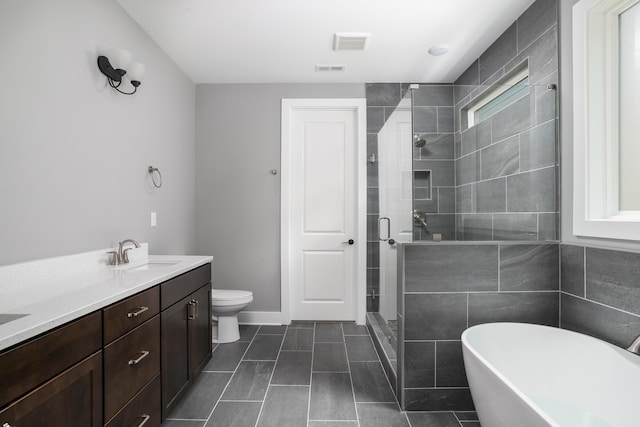 bathroom featuring visible vents, double vanity, a soaking tub, a sink, and a stall shower