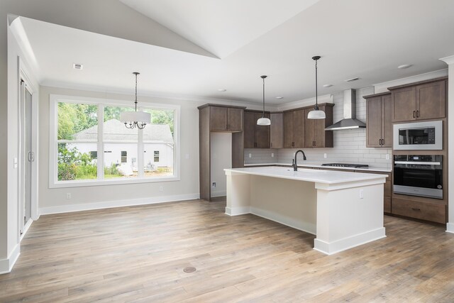 kitchen with wall chimney range hood, oven, light countertops, built in microwave, and decorative backsplash