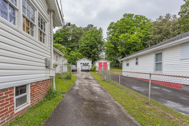109 Sequoia Dr, Chattanooga, TN 37411 - view of side of property featuring asphalt driveway, fence, a garage, and an outbuilding