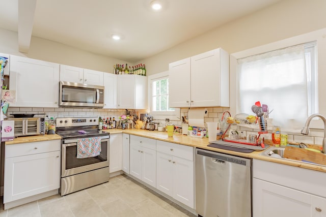 109 Sequoia Dr, Chattanooga, TN 37411 - kitchen featuring appliances with stainless steel finishes, a sink, backsplash, light countertops, and white cabinets