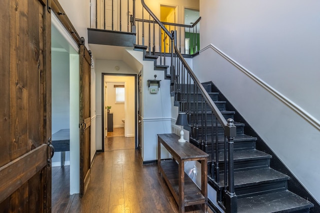 9505 Post Oak Dr, Ooltewah, TN 37363 - staircase with baseboards, a high ceiling, wood-type flooring, and a barn door