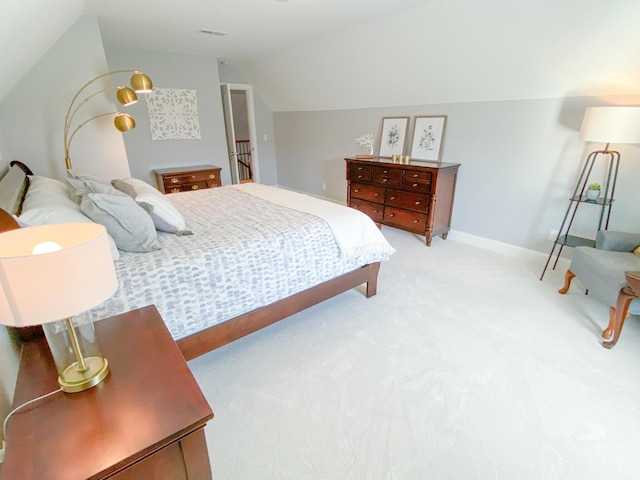 bedroom with baseboards, visible vents, light carpet, and lofted ceiling