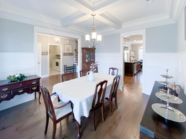dining area featuring ornamental molding, washer / dryer, a decorative wall, beam ceiling, and coffered ceiling