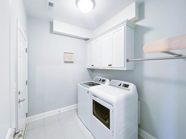 laundry room featuring visible vents, washing machine and dryer, baseboards, cabinet space, and light tile patterned floors