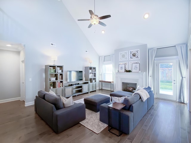 living room featuring ceiling fan, high vaulted ceiling, baseboards, wood finished floors, and visible vents