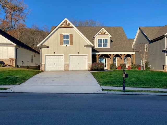 craftsman inspired home with a garage, board and batten siding, a front yard, and concrete driveway