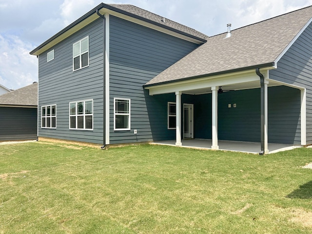 rear view of property featuring roof with shingles, a patio area, ceiling fan, and a lawn