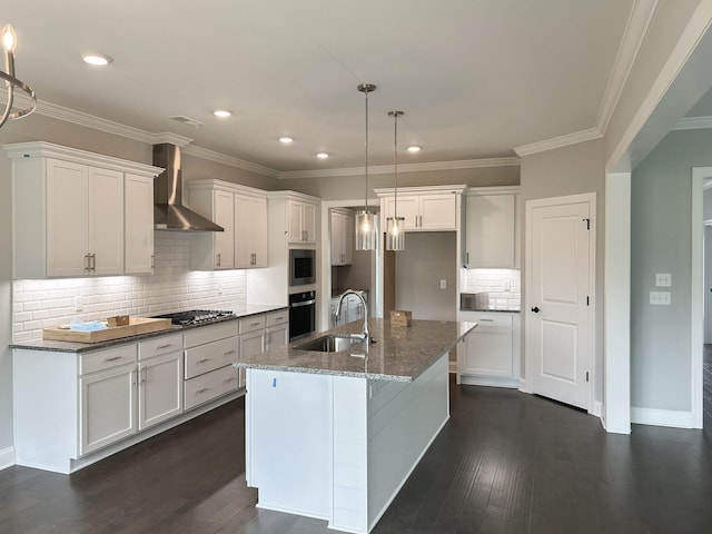 kitchen featuring dark wood finished floors, a sink, wall chimney exhaust hood, and tasteful backsplash