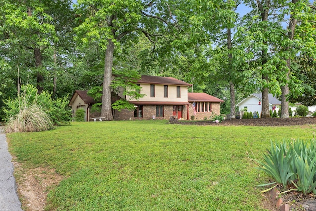 split level home with brick siding and a front yard
