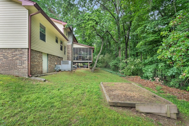 view of yard featuring central air condition unit and a sunroom