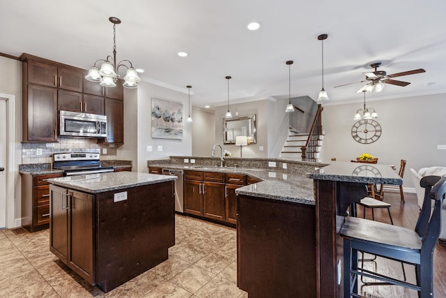 kitchen with crown molding, a kitchen island, stainless steel appliances, and tasteful backsplash