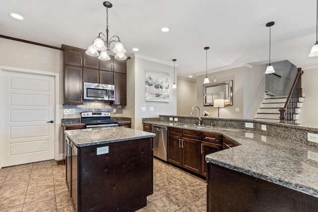 kitchen with a sink, crown molding, a kitchen island, and stainless steel appliances