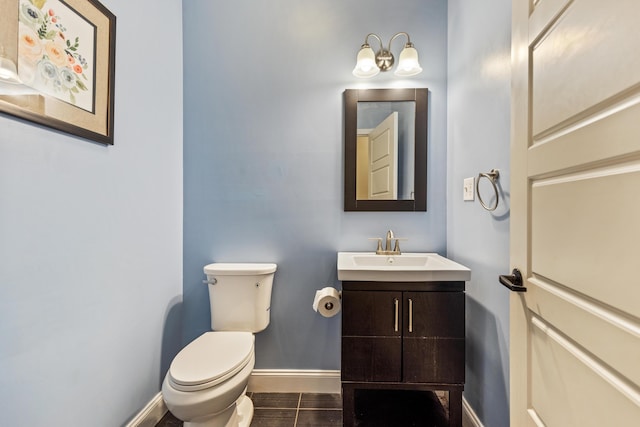 half bathroom featuring baseboards, vanity, and toilet
