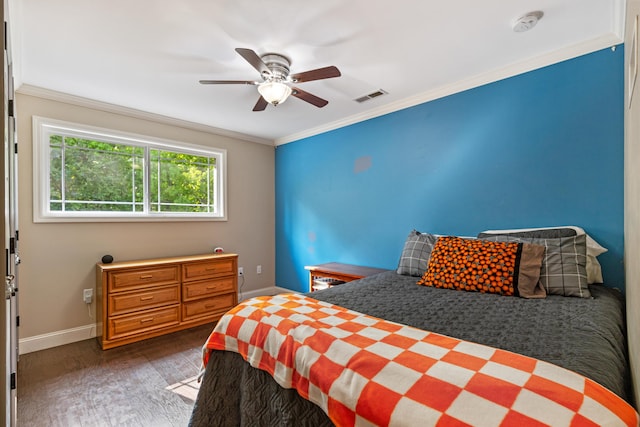 bedroom featuring crown molding, a ceiling fan, baseboards, wood finished floors, and visible vents