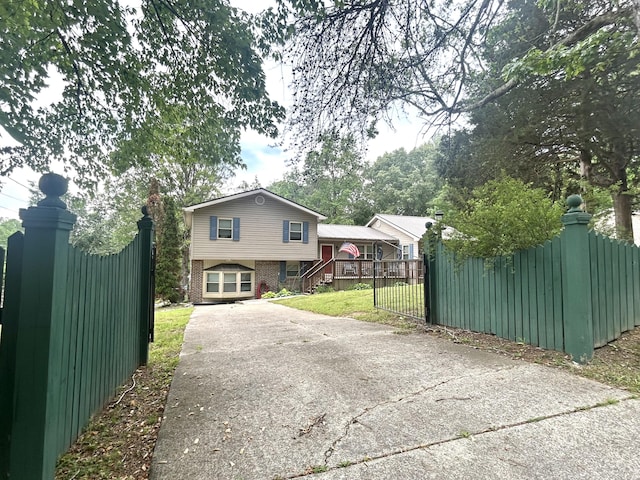 exterior space with brick siding, driveway, and fence