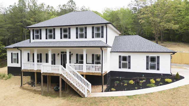 view of front of property featuring a porch, roof with shingles, and stairway