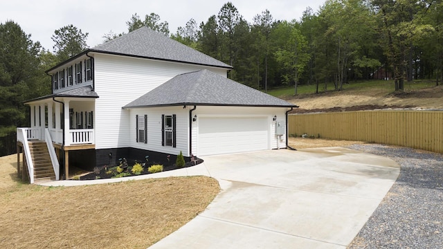 view of front facade with a shingled roof, a garage, stairway, covered porch, and driveway