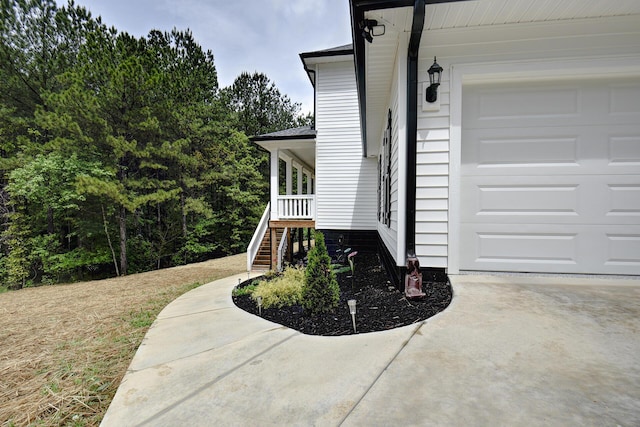 view of home's exterior with concrete driveway, stairs, and a garage