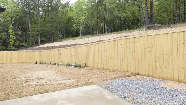 view of yard with fence and a view of trees