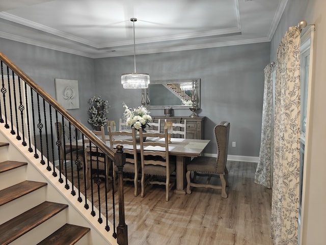 dining area featuring baseboards, a notable chandelier, ornamental molding, and wood finished floors