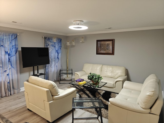 living room featuring light wood-style floors, baseboards, and ornamental molding