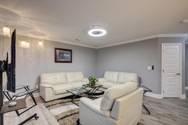 living room with crown molding, visible vents, baseboards, a chandelier, and light wood finished floors