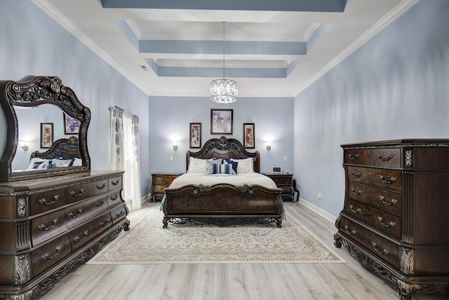 bedroom featuring an inviting chandelier, ornamental molding, wood finished floors, baseboards, and a raised ceiling