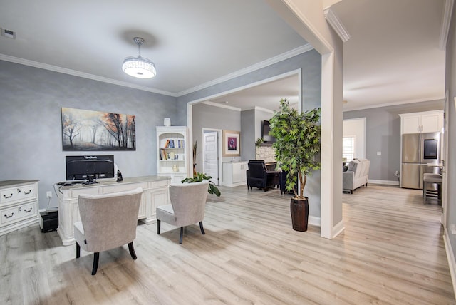 interior space featuring baseboards, ornamental molding, and light wood finished floors