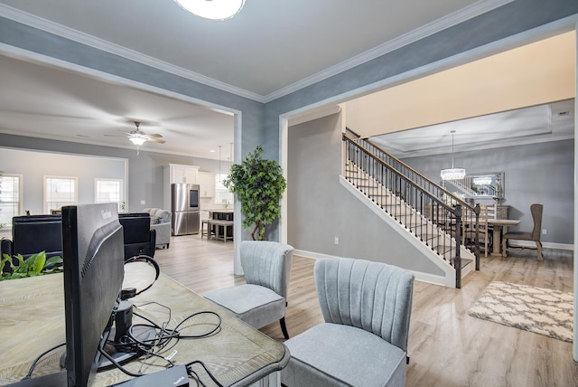 dining room featuring light wood-type flooring, baseboards, ceiling fan, and stairway