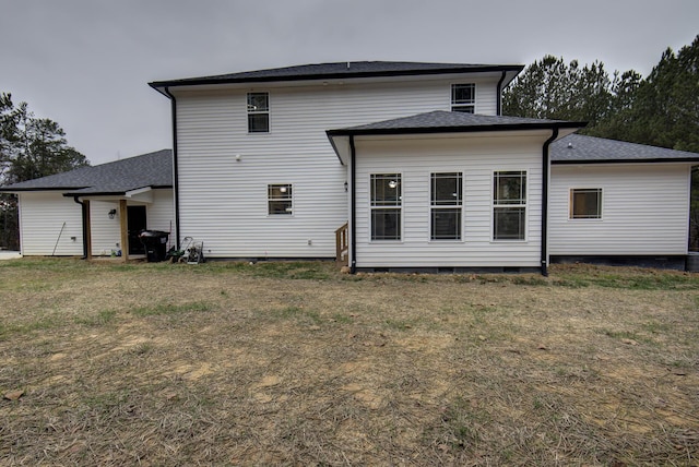 rear view of house with a lawn and a shingled roof
