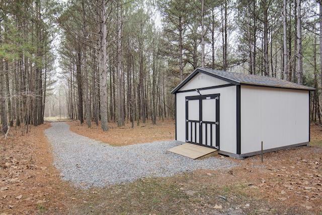 view of shed with a wooded view