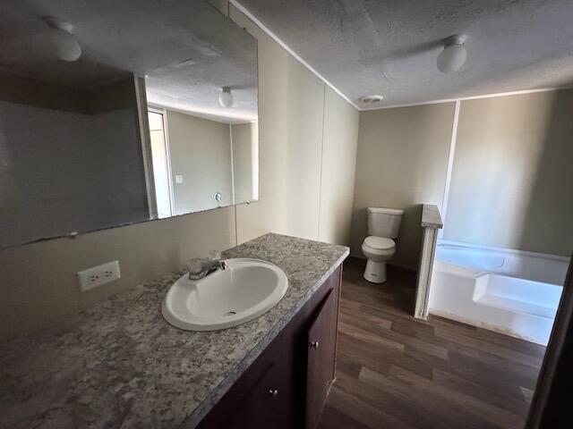 401 Old Cottonwood Mill Rd, Tunnel Hill, GA 30755 - full bathroom featuring toilet, wood finished floors, a garden tub, and vanity