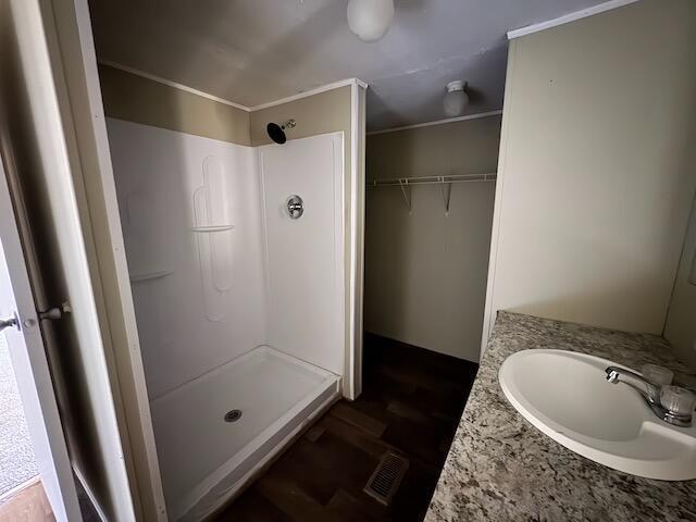 401 Old Cottonwood Mill Rd, Tunnel Hill, GA 30755 - bathroom featuring ornamental molding, visible vents, a shower stall, and a sink