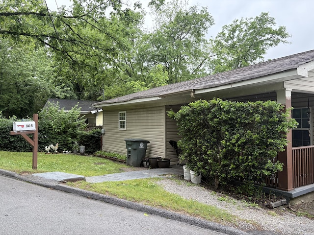 view of property exterior with a yard and roof with shingles