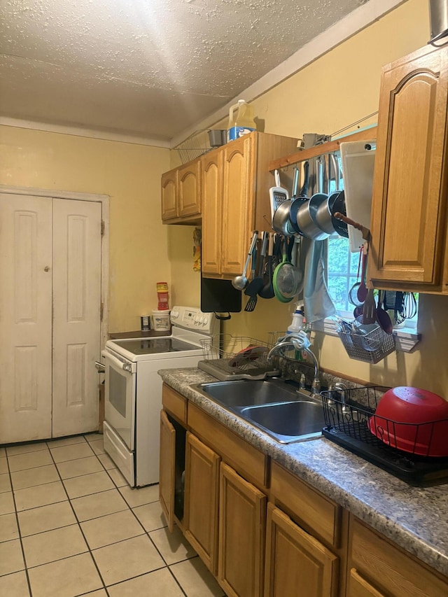 kitchen featuring white electric stove, a textured ceiling, light tile patterned flooring, and a sink
