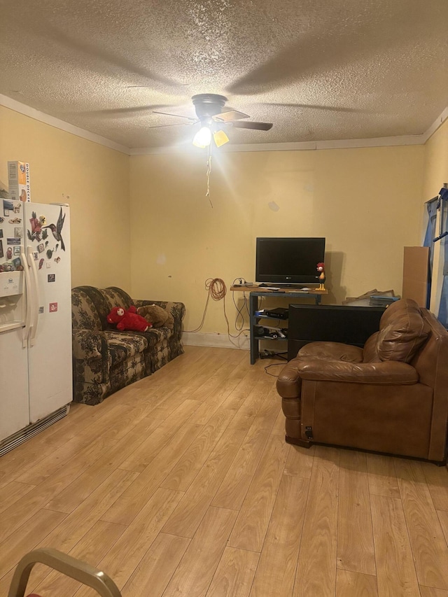 living room featuring crown molding, a textured ceiling, light wood-style flooring, and a ceiling fan
