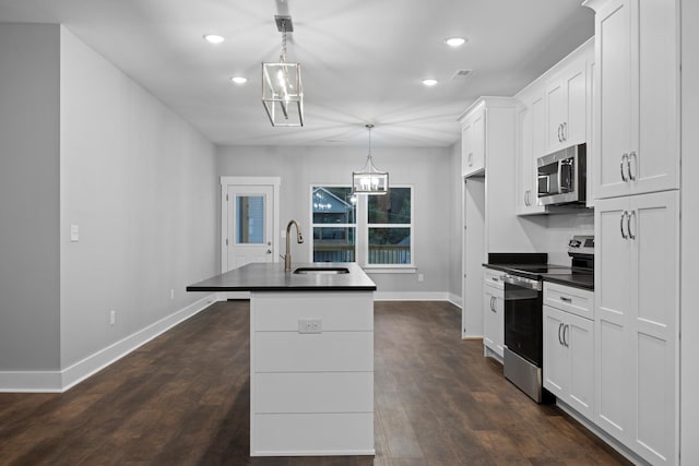 kitchen with baseboards, a sink, appliances with stainless steel finishes, and dark countertops